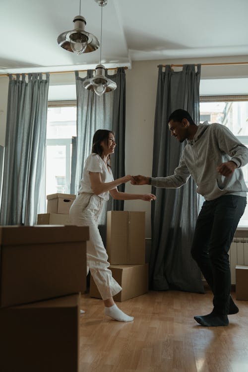 Free Man in White Dress Shirt and Black Pants Standing Beside Woman in White Long Sleeve Shirt Stock Photo