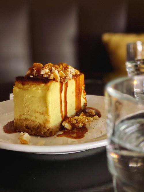 Free Yummy sweet piece of biscuit dessert with cream and nut crumb on top on white plate in cafe Stock Photo