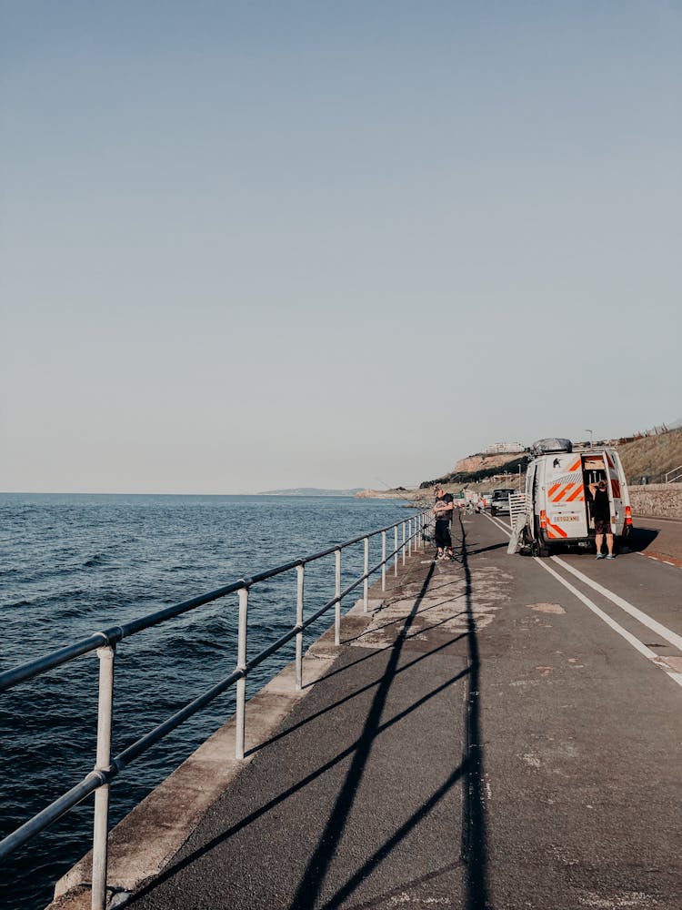 Road Going Along Blue Sea Under Clear Sky