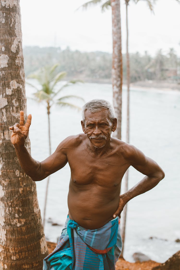 Ethnic Old Man Standing On Coast Of River