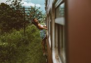 Ethnic woman leaning out of train standing in exit door