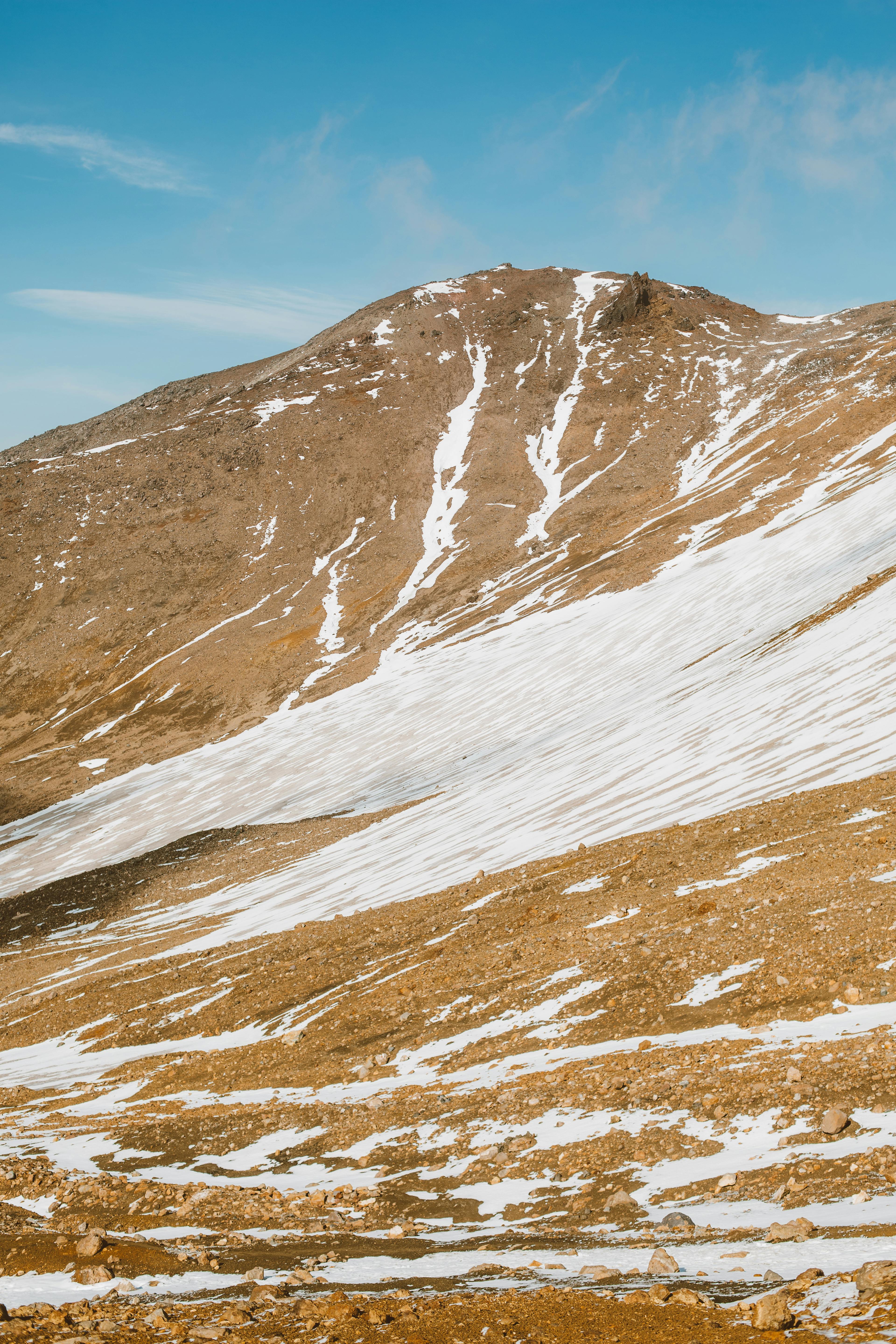 Prescription Goggle Inserts - Mountain slope covered with snow and stones under blue sky with clouds in clear day