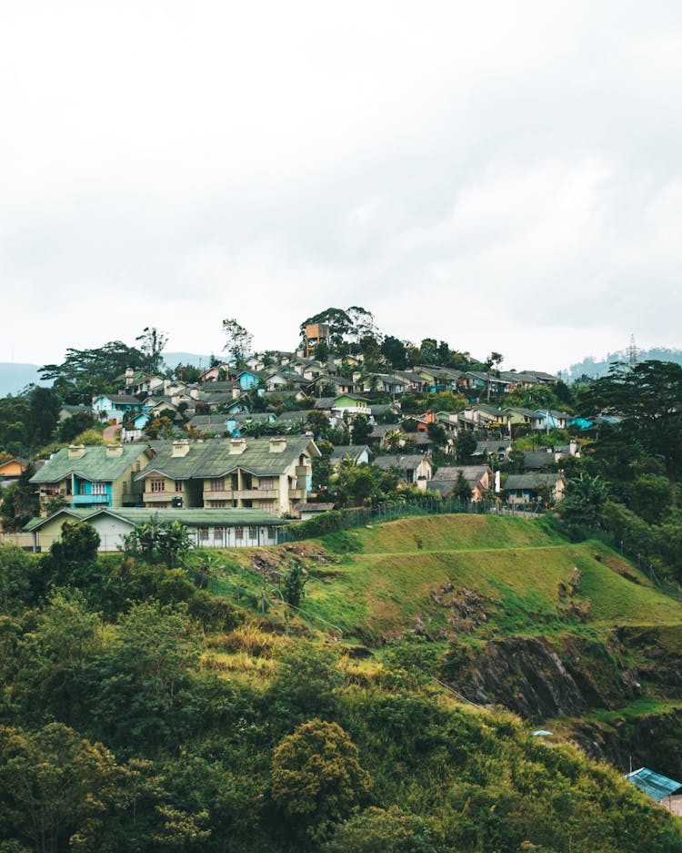 Small Village On Green Hill On Cloudy Day