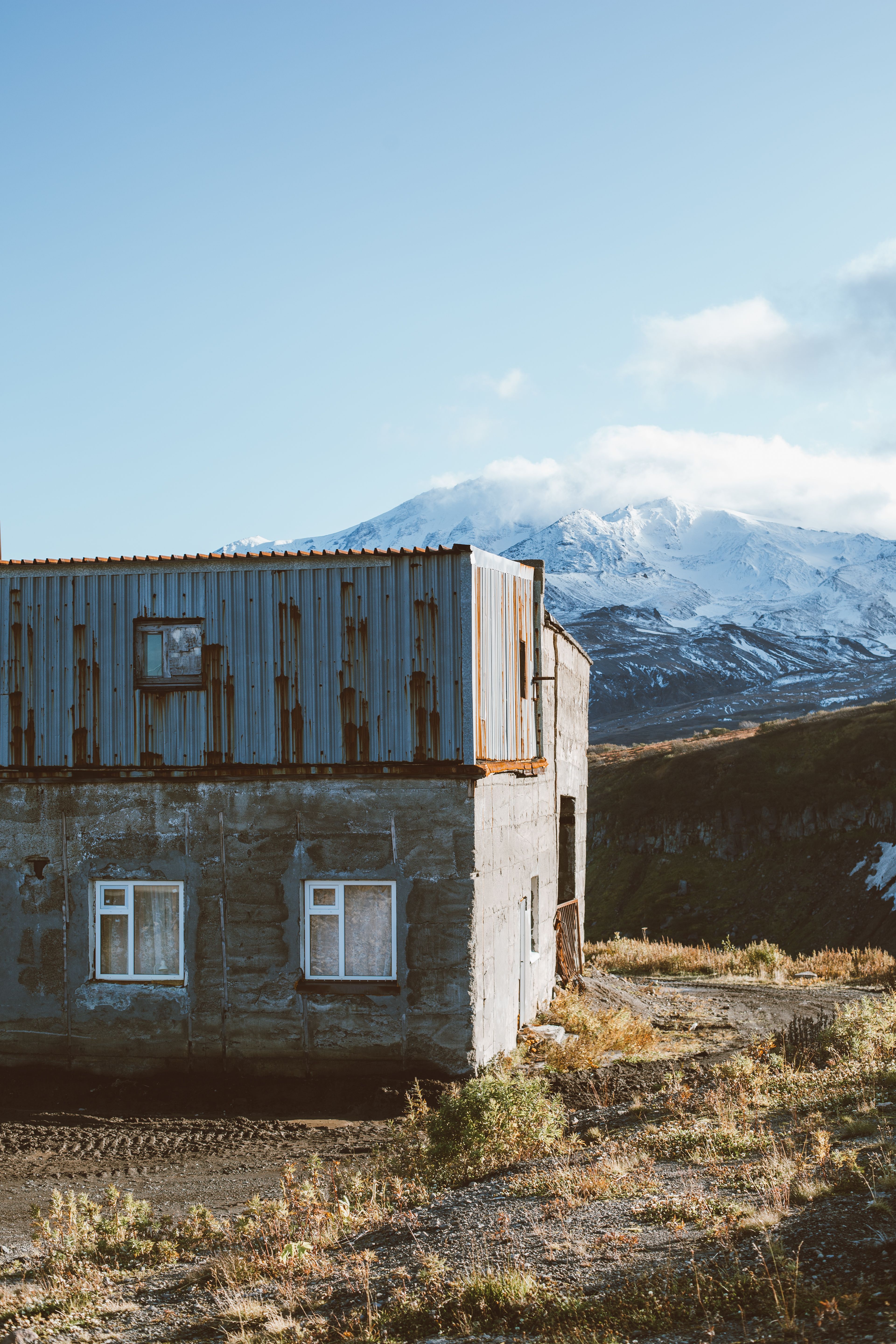 雪山脚下，一座风化的小屋静静伫立，风景宁静