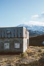 雪山脚下，一座风化的小屋静静伫立，风景宁静