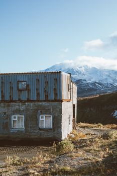 雪山脚下，一座风化的小屋静静伫立，风景宁静