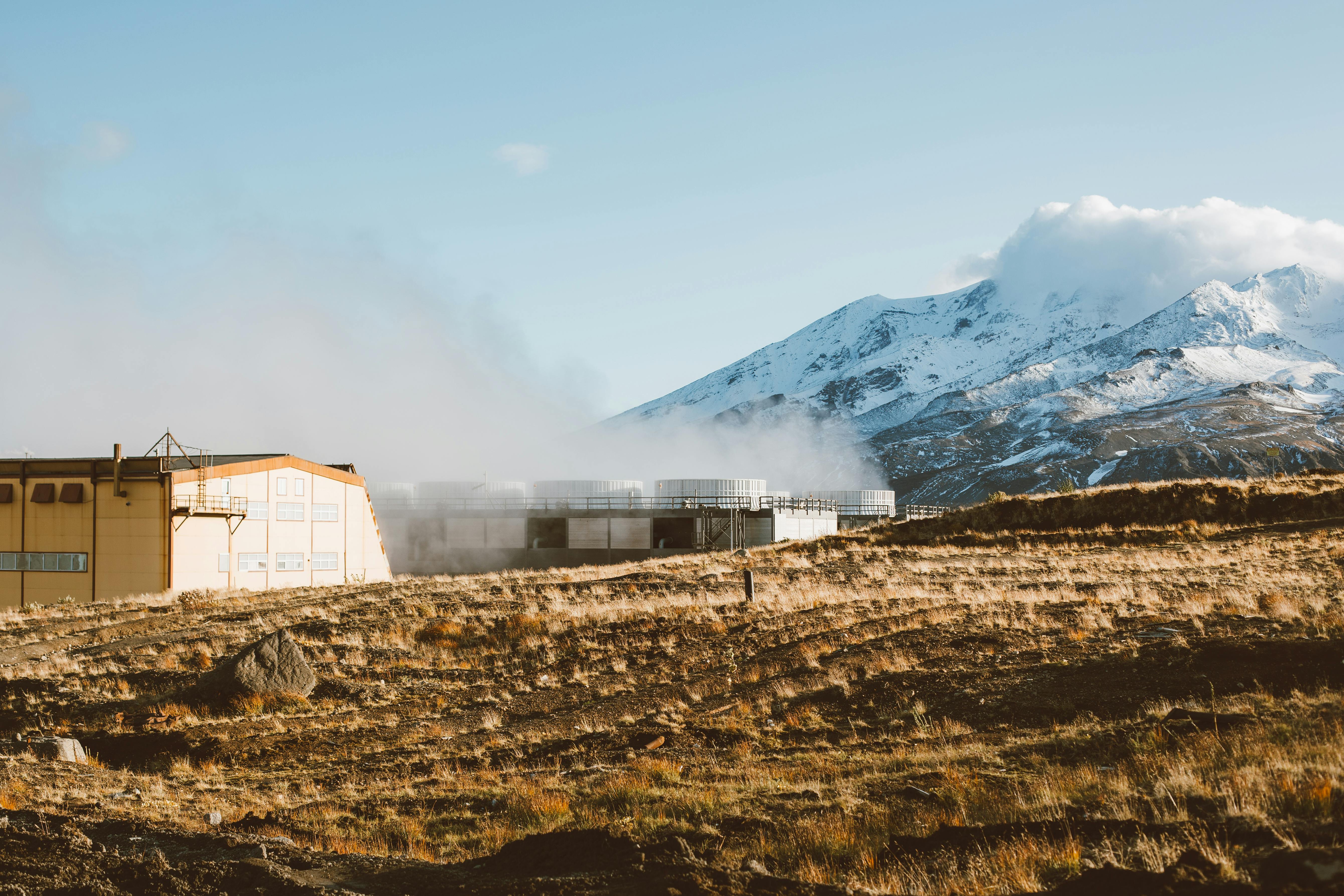一座工业建筑映衬着白雪皑皑的山地景观，显得格外宁静