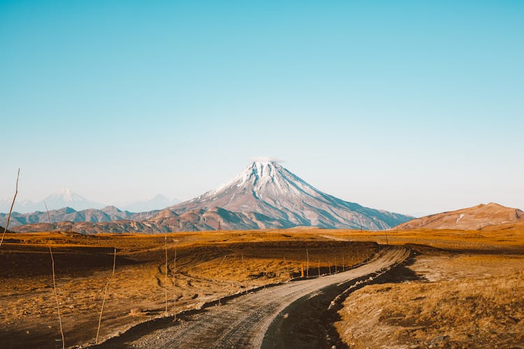 Landscape Of Road Leading To Distant Mountain