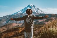 男子俯瞰堪察加半岛的火山景观，伸出双臂
