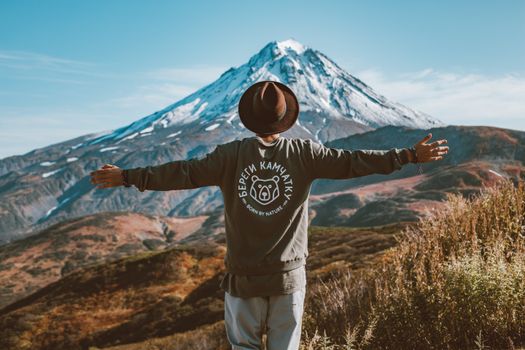 男子俯瞰堪察加半岛的火山景观，伸出双臂
