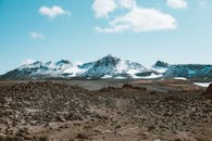 远处积雪覆盖的山脊和沙漠岩石山谷的壮丽景色，映衬在蓝天下