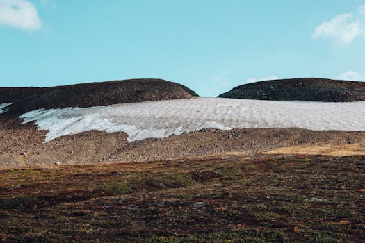 Beautiful serene mountain landscape with snowcapped peaks and clear blue sky.