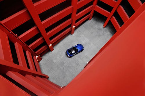 Free Blue Car Parked Beside Red Concrete Building Stock Photo