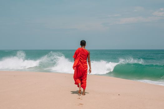 Unrecognizable young ethnic man walking on seashore