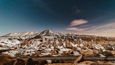 黄昏时分，卡帕多西亚白雪皑皑的美丽风景在星空下，展现出自然的岩石结构