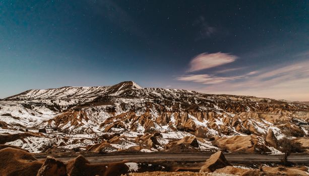 黄昏时分，卡帕多西亚白雪皑皑的美丽风景在星空下，展现出自然的岩石结构
