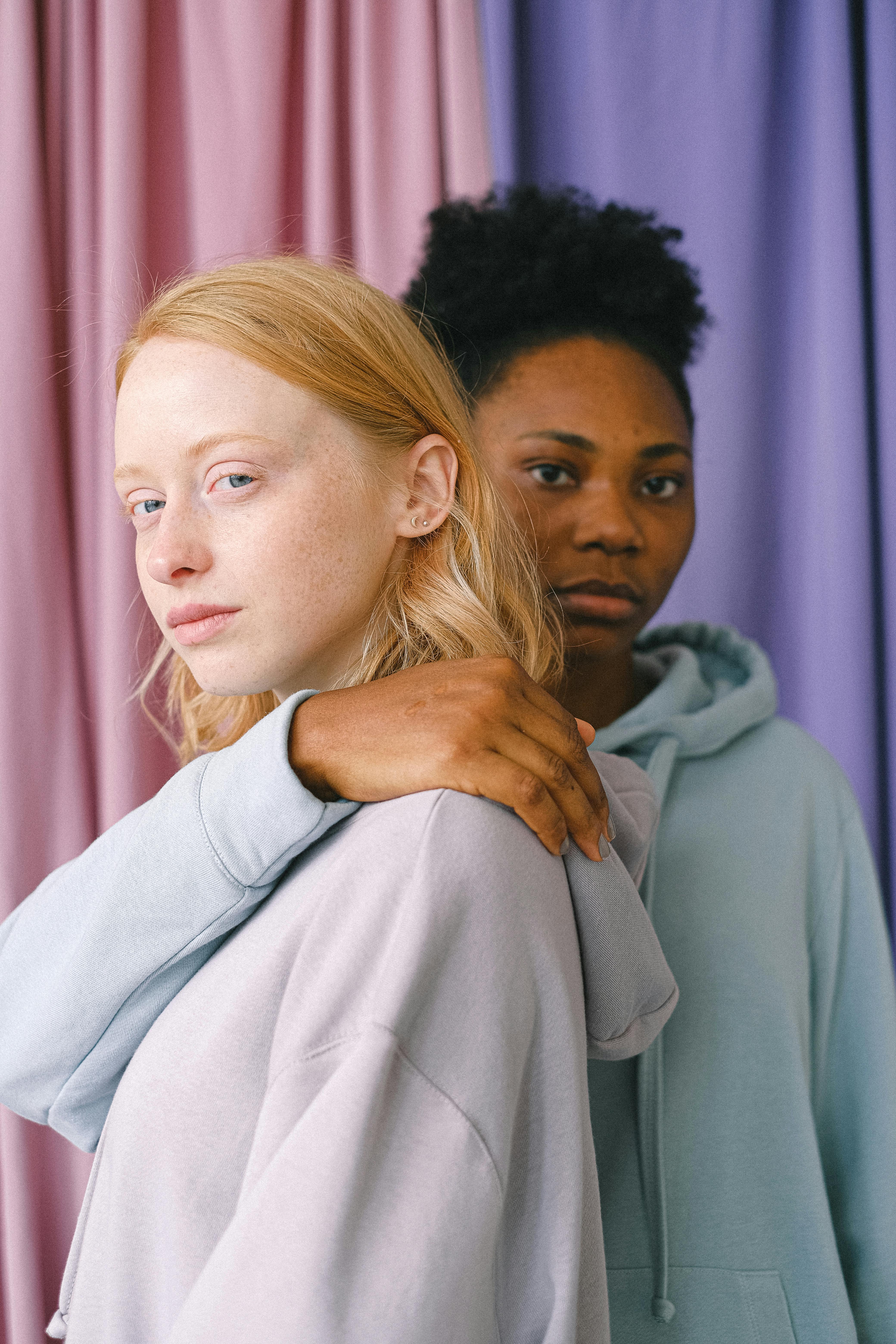 two women wearing long sleeve hoodies