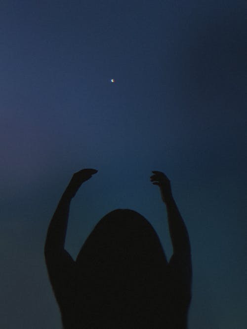 Free A Person Raising Hands During Night Time Stock Photo