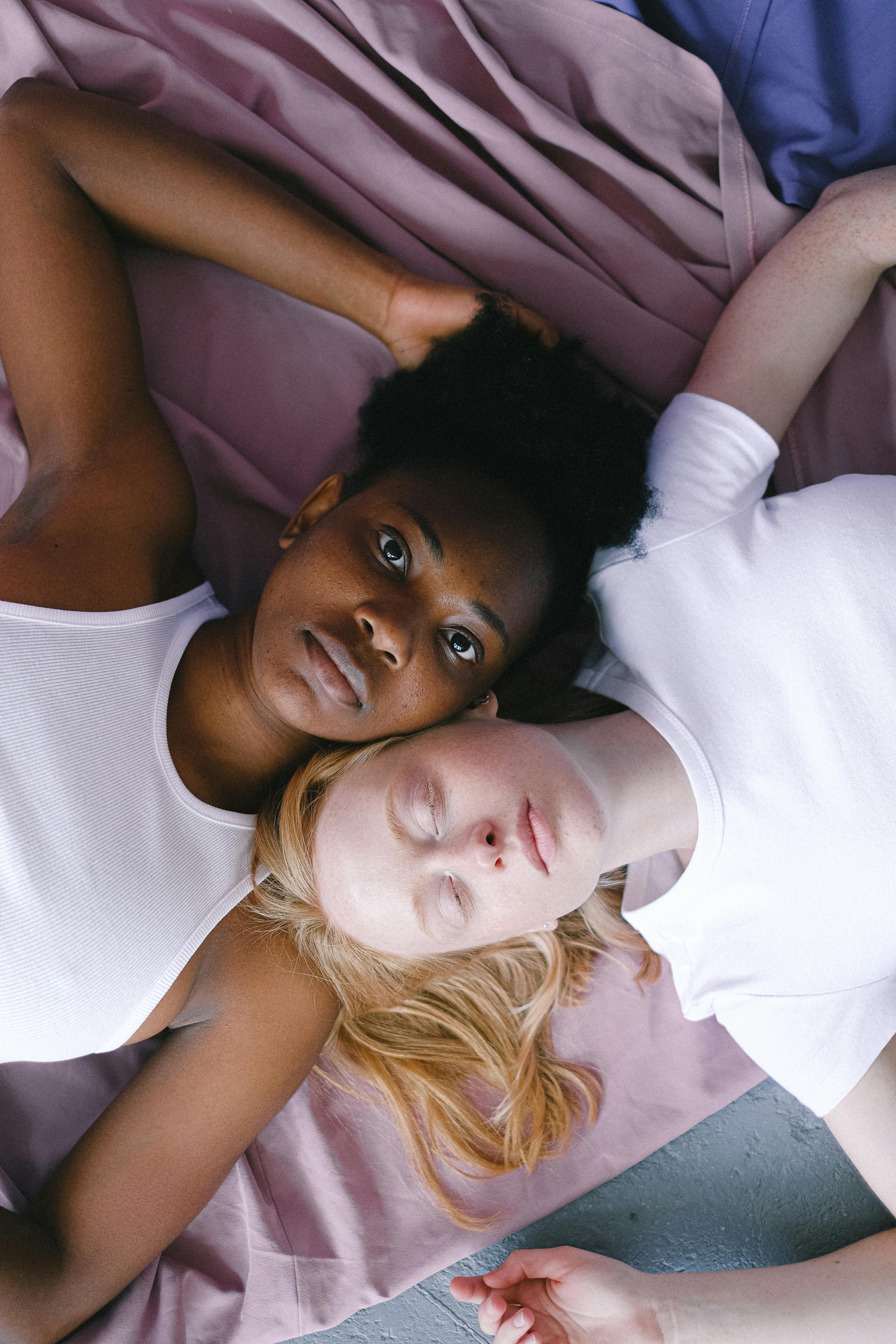interracial women lying head to head in opposite directions