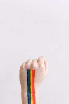 一只手涂着彩虹色的身体彩绘，在白色背景下摆出骄傲的姿态