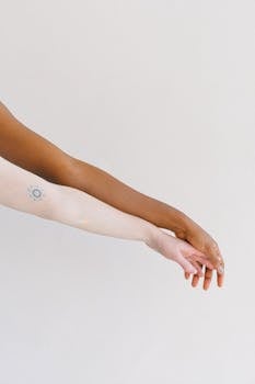 Two arms of different skin tones displayed on a white background, one with a tattoo.