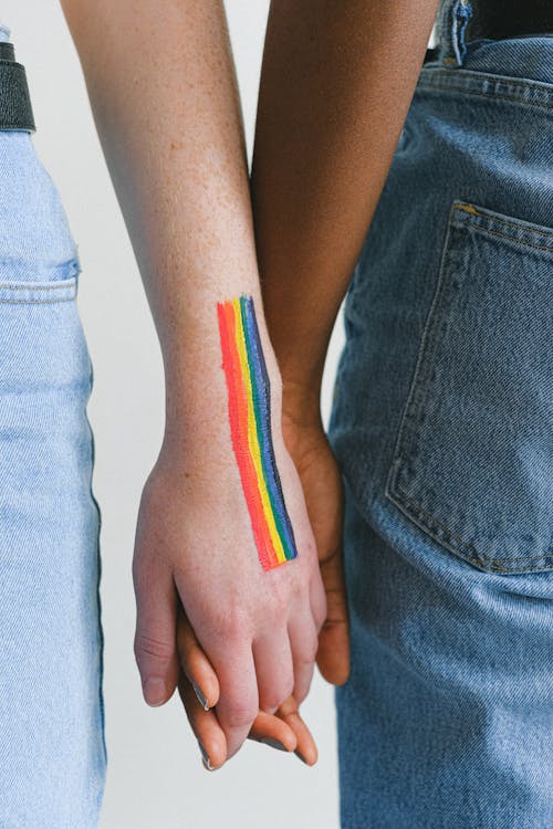 Free People with Gay Pride Body Paint Holding Hands Stock Photo