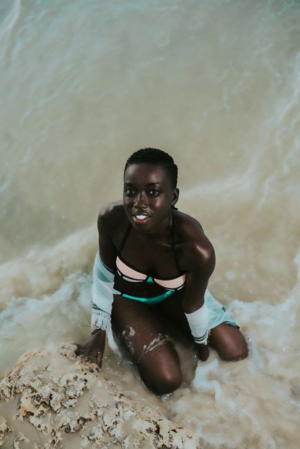 Elegant African woman in bikini posing on a scenic beach in Dar es Salaam, Tanzania.