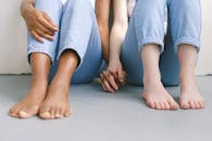 特写镜头中，一对跨种族夫妇赤脚并排坐着、牵着手，象征着团结和爱