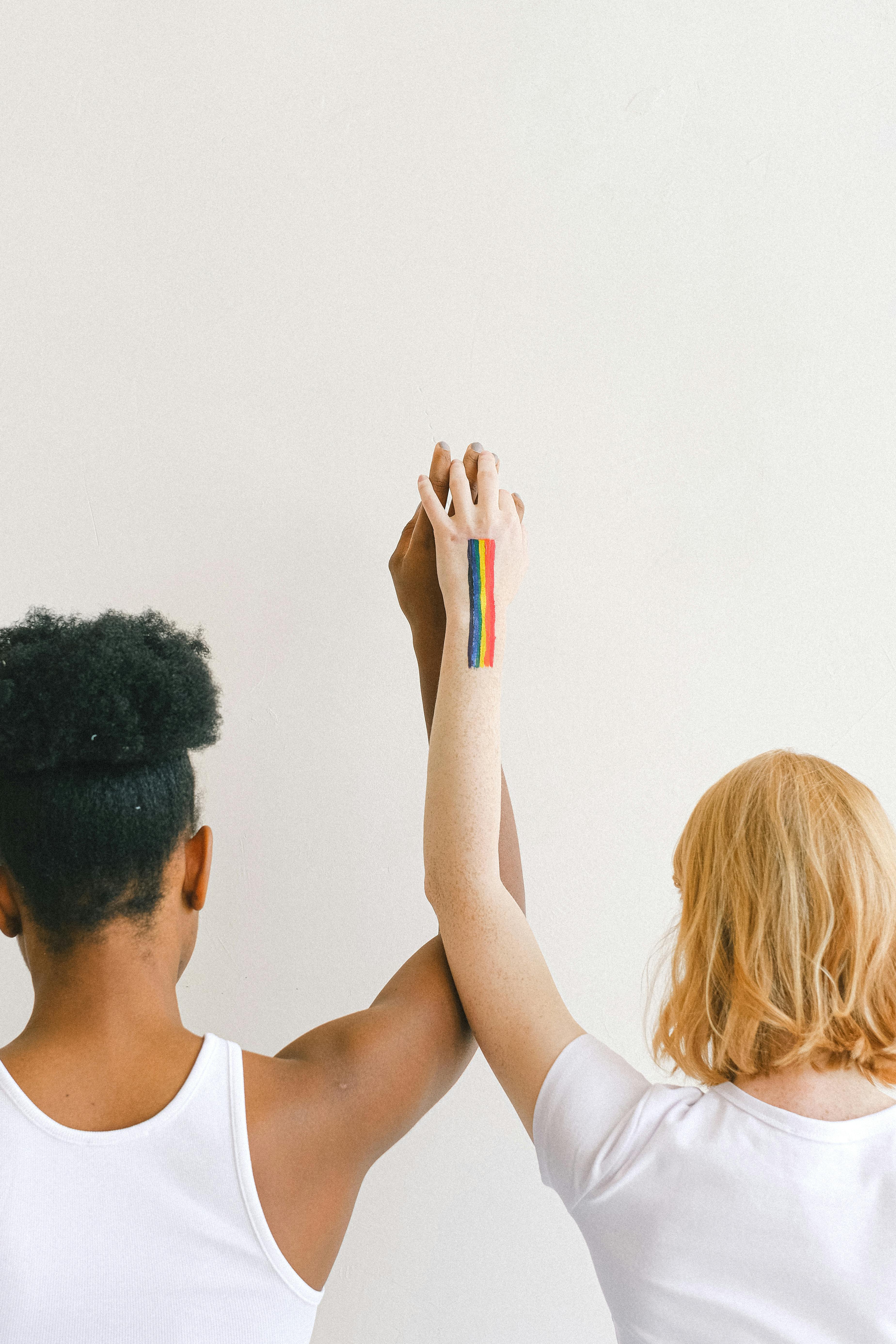 women with arms raised and holding hands