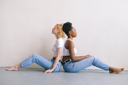 Women Back to Back Sitting on the Floor