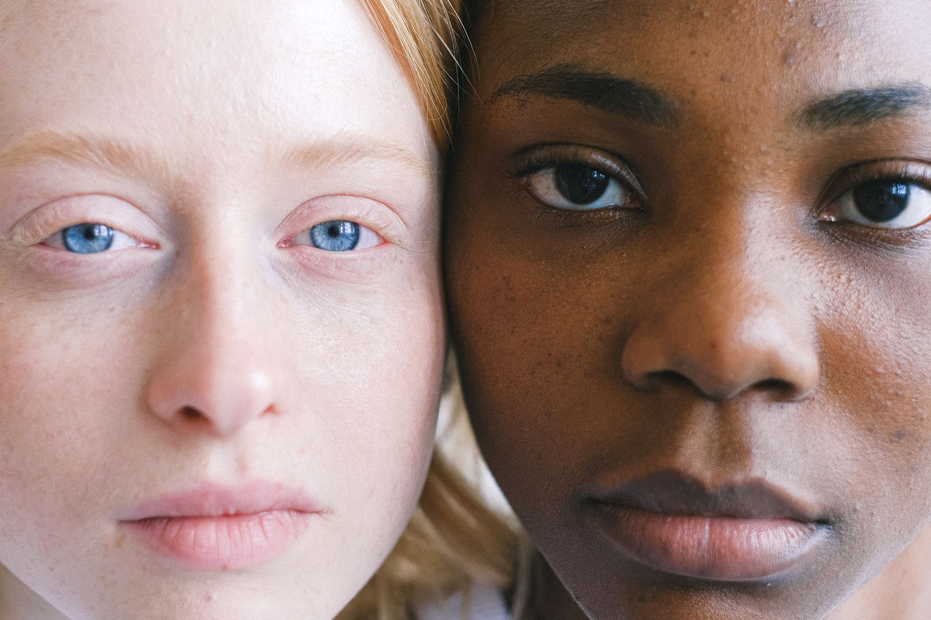 A close-up portrait highlighting diverse facial features and expressions of two women.