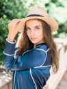 Confident stylish young woman in straw hat