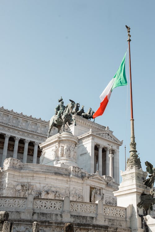 Majestic classical monument with waving flag nearby