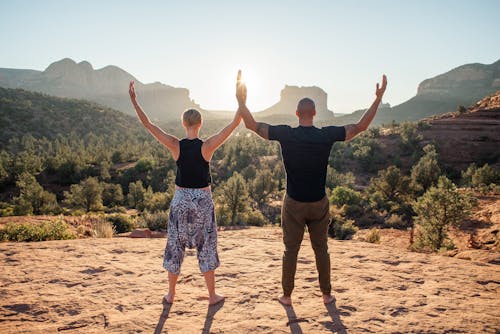 Male and female doing yoga together in nature in summer