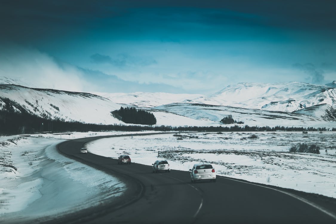 Cars driving on road in snowy valley