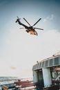 Low angle of modern helicopter flying over ship floating in rippling sea on sunny day