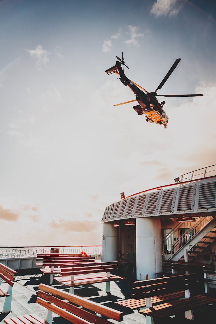 Helicopter Flying Over Ship Deck At Sundown