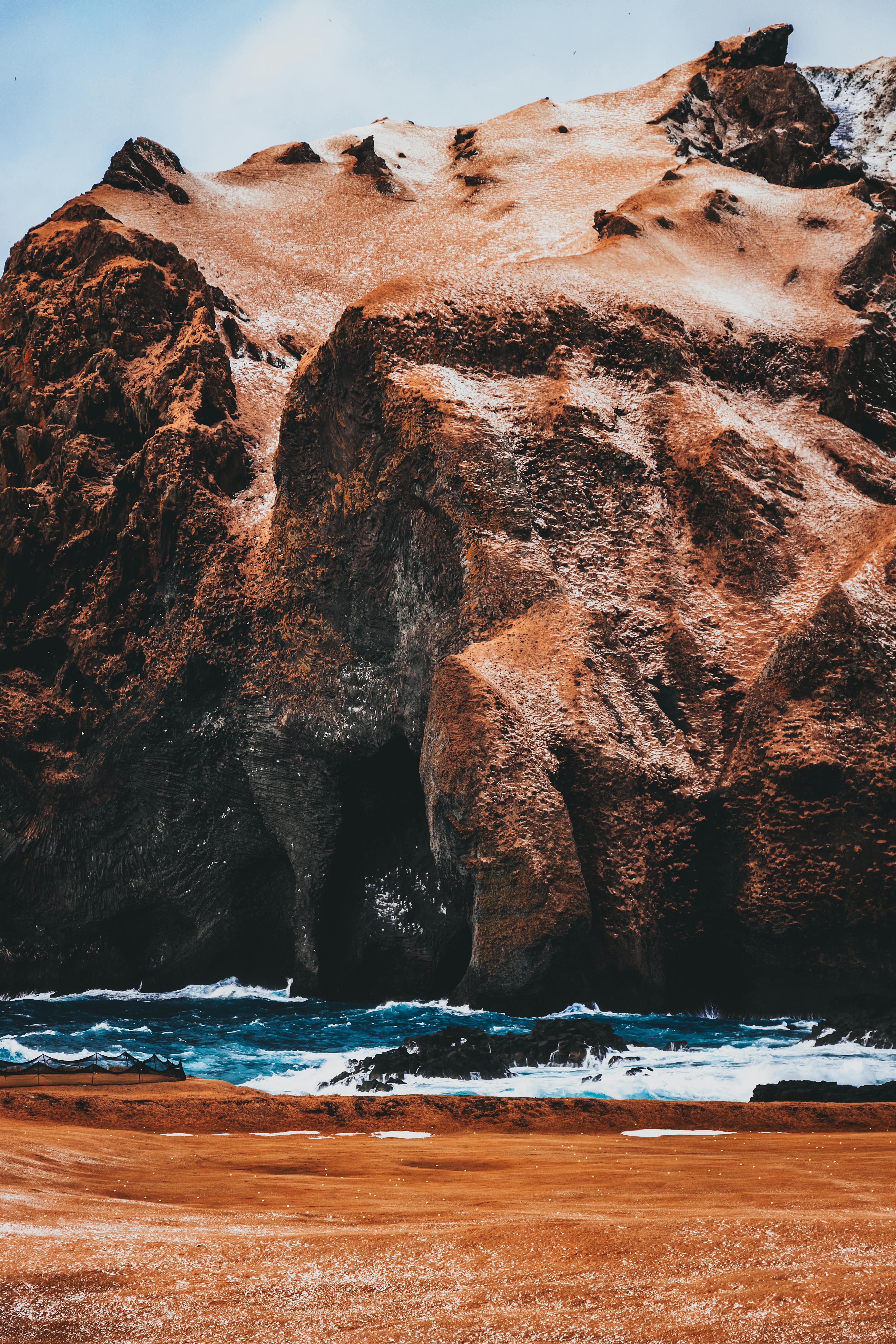 Steep rock near blue bay · Free Stock Photo