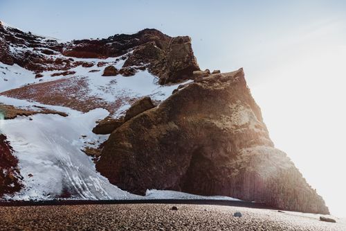 Free Light blue cloudless sky over high brown mountain slope covered with snow in sunlight Stock Photo