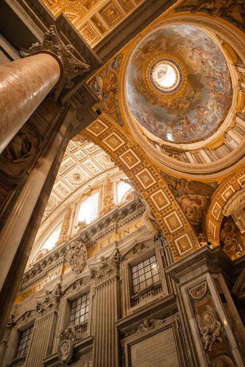 From below of majestic ornamental walls and dome with Renaissance frescos of Papal Basilica of Saint Peter in Vatican