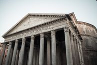 From below of antique Rome Pantheon portico with granite Corinthian columns and Latin inscription on facade