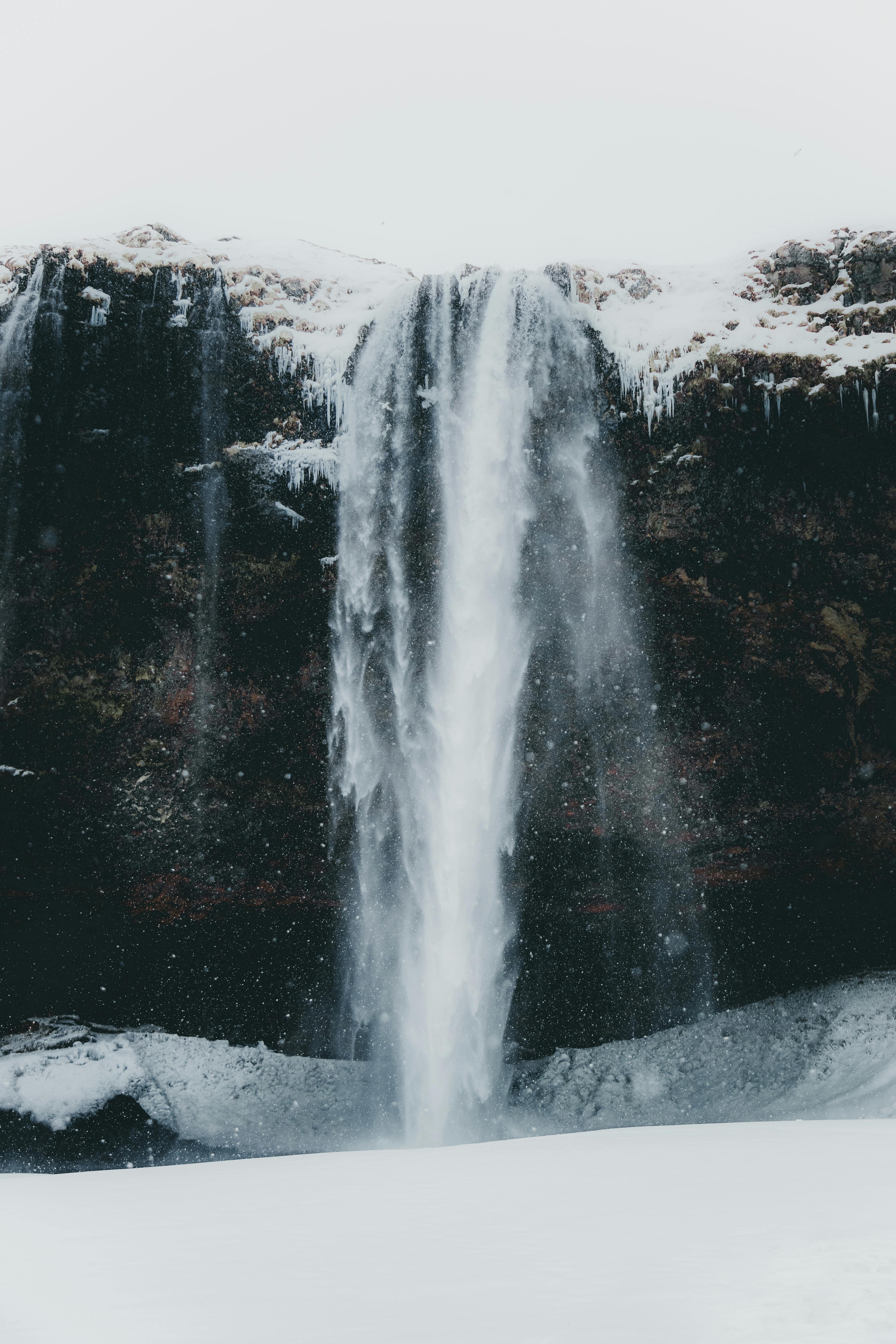 snowy stream flowing on frozen ground