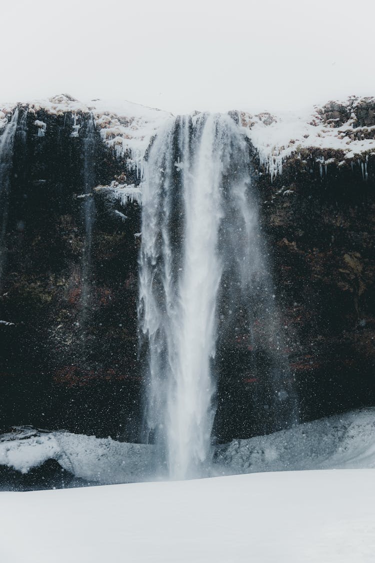 Snowy Stream Flowing On Frozen Ground