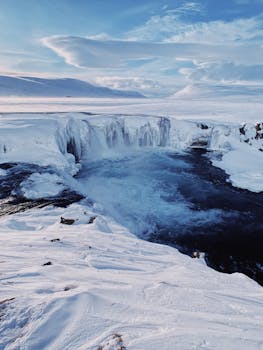 Breathtaking view of a frozen waterfall in Iceland's snowy landscape. Perfect for nature enthusiasts.