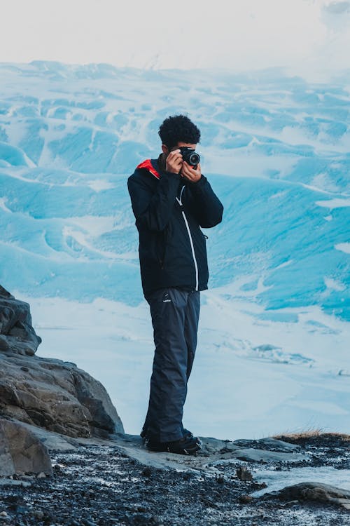 Anonymous man taking shot of winter nature