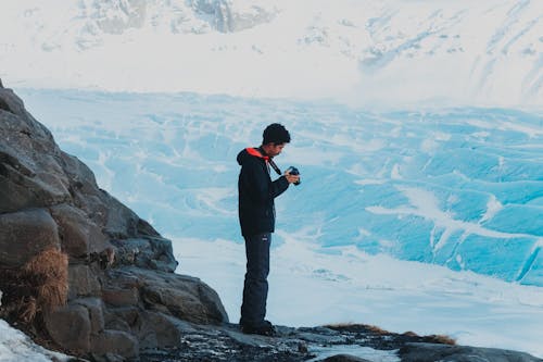 Man with camera in hands in winter mountains