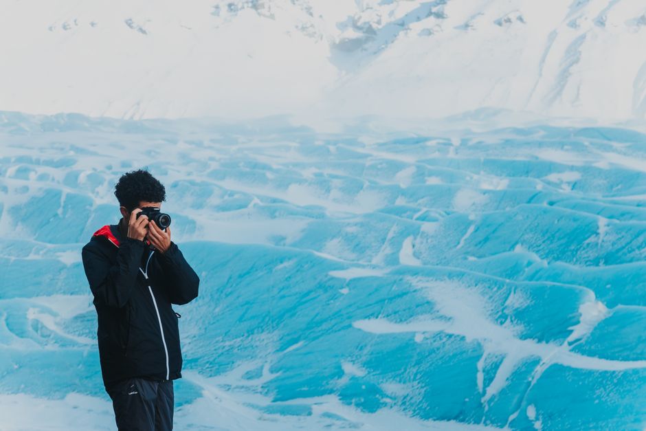 Knik Glacier Helicopter Flight-90 Mins-1 Landing-Anchorage Area - From above of male photographer standing near snowy pit and taking pictures of frozen surface while spending day in nature