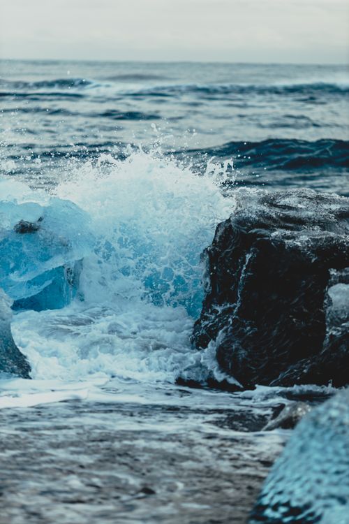 Free Rough cliff washed with splashing crystal ocean waves with flowing chunks of cold ice Stock Photo
