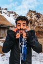 Ethnic guy with mustache with icicles in mouth showing walrus tusks while looking at camera