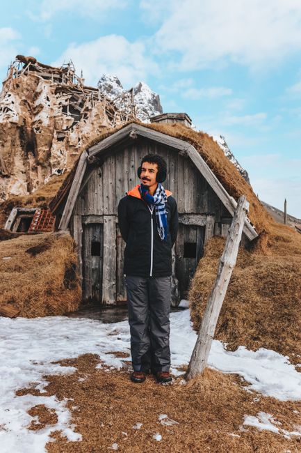 Photo by Matheus Bertelli on Pexels Full length man in warm earmuffs and outerwear standing against shabby wooden cabin in cold remote settlement
